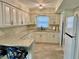 Well-lit kitchen featuring granite countertops, ample cabinet space, and a stylish overhead light fixture at 7026 20Th N St, St Petersburg, FL 33702