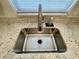 Close-up of a modern stainless steel kitchen sink with a granite countertop and natural light at 7026 20Th N St, St Petersburg, FL 33702