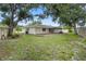 View of backyard featuring green grass, landscaping, and mature trees at 7108 14Th Nw Ave, Bradenton, FL 34209