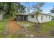 View of backyard featuring green grass, landscaping, trees, and a screened in porch at 7108 14Th Nw Ave, Bradenton, FL 34209