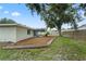 View of backyard featuring green grass, landscaping, trees, and a screened in porch at 7108 14Th Nw Ave, Bradenton, FL 34209