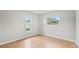 Empty bedroom with wood floors, fresh paint, and two bright windows offering views of the yard at 7108 14Th Nw Ave, Bradenton, FL 34209