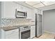 Close-up view of the kitchen featuring stainless appliances, tile backsplash, and white cabinetry at 7108 14Th Nw Ave, Bradenton, FL 34209