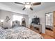 Bedroom featuring wooden floors, ceiling fan, a bed and decor hanging from the walls at 7619 Limington Dr, Port Richey, FL 34668