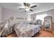Bedroom featuring wooden floors, ceiling fan, a bed and decor hanging from the walls at 7619 Limington Dr, Port Richey, FL 34668
