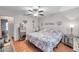 Bedroom featuring wooden floors, ceiling fan, a bed and decor hanging from the walls at 7619 Limington Dr, Port Richey, FL 34668