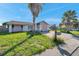 Charming single-story home with a one-car garage surrounded by a green lawn and mature trees at 7619 Limington Dr, Port Richey, FL 34668