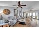 Bright and inviting living room with hardwood floors and a ceiling fan, adjacent to the dining area at 7619 Limington Dr, Port Richey, FL 34668