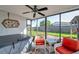 Sunroom featuring a hot tub, fan and white furniture with red cushions at 7619 Limington Dr, Port Richey, FL 34668