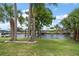 Beautiful backyard with a dock on the water, surrounded by lush green grass and mature palm trees at 911 Sago Palm Way Way, Apollo Beach, FL 33572