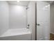 Bright bathroom featuring a bathtub with a tiled shower and a white door at 911 Sago Palm Way Way, Apollo Beach, FL 33572
