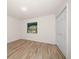 Bedroom with wood-look flooring, a window offering outdoor views and a closet at 911 Sago Palm Way Way, Apollo Beach, FL 33572