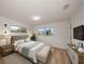 Well-lit bedroom with wood floors, a comfortable bed, and a modern TV console with a flat screen television at 911 Sago Palm Way Way, Apollo Beach, FL 33572