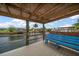 Dock with wooden canopy featuring seating with views of the calm water and neighboring boat docks at 911 Sago Palm Way Way, Apollo Beach, FL 33572