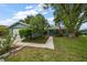 Charming single-story home with a well-manicured lawn, mature trees, and inviting landscaping at 911 Sago Palm Way Way, Apollo Beach, FL 33572