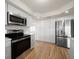 Stylish kitchen featuring white cabinets, quartz countertops, stainless steel appliances and wood floors at 911 Sago Palm Way Way, Apollo Beach, FL 33572