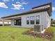 Back exterior showcasing the covered patio, windows, and modern architectural design at 15003 Rider Pass Dr, Lithia, FL 33547