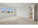 Bright bedroom with multiple windows, tray ceiling, and neutral carpeting at 15003 Rider Pass Dr, Lithia, FL 33547