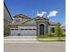 Charming home featuring a symmetrical facade, three-car garage and a tile roof at 15003 Rider Pass Dr, Lithia, FL 33547