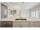 Modern kitchen with an island featuring a stainless-steel sink, dishwasher, and marble countertop at 15003 Rider Pass Dr, Lithia, FL 33547