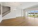 Open-concept living room boasts sleek wood floors and sliding glass doors leading to outdoor views at 15003 Rider Pass Dr, Lithia, FL 33547