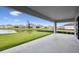 Covered patio overlooking a scenic backyard with a pond view and lush green lawn at 15003 Rider Pass Dr, Lithia, FL 33547