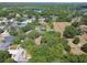A captivating aerial view of a residential community with mature landscaping, tennis court and lakes at 15209 Hammock Chase Ct, Odessa, FL 33556