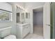 Bathroom featuring a white vanity, large mirror with decorative lights, and tile flooring at 15209 Hammock Chase Ct, Odessa, FL 33556