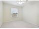 Clean and minimal bedroom bathed in neutral colors featuring a ceiling fan and window at 15209 Hammock Chase Ct, Odessa, FL 33556