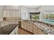 Spacious kitchen with granite countertops, modern appliances, and light wood flooring with view of the pool at 15209 Hammock Chase Ct, Odessa, FL 33556