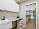 Practical laundry area equipped with sink, storage solutions, and seamless connection to main living spaces at 15209 Hammock Chase Ct, Odessa, FL 33556