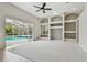 Open concept living room with sliding glass doors leading to pool and decorative shelving at 15209 Hammock Chase Ct, Odessa, FL 33556