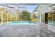 Enclosed pool with brick floor and access to the interior through glass sliding doors at 15209 Hammock Chase Ct, Odessa, FL 33556