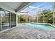 Enclosed pool with brick floor and access to the interior through glass sliding doors at 15209 Hammock Chase Ct, Odessa, FL 33556