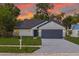 Charming single-story home with a well-manicured lawn and a two-car garage at sunset at 2908 Longbrooke Way, Clearwater, FL 33760
