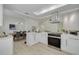 Bright kitchen featuring stainless steel appliances, white cabinetry, and an open layout to the dining area at 2908 Longbrooke Way, Clearwater, FL 33760