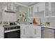 Modern kitchen with stainless steel appliances, white cabinets, and view of the living room with fireplace at 2908 Longbrooke Way, Clearwater, FL 33760