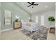 Main bedroom features a light green accent wall, a ceiling fan, light wood floor, and access to a private balcony at 2908 Longbrooke Way, Clearwater, FL 33760