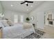 Main bedroom showcasing double doors to the backyard, a ceiling fan, and an ensuite bathroom at 2908 Longbrooke Way, Clearwater, FL 33760