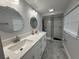 Modern bathroom with dual sinks, stylish mirrors, and a glass-enclosed shower featuring attractive tile accents at 2927 W Henry Ave, Tampa, FL 33614