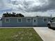 Single-story home with a light blue exterior, well-maintained lawn, and a concrete driveway at 2927 W Henry Ave, Tampa, FL 33614