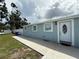 Charming single-story home with a white door, light blue exterior and a well-kept lawn at 2927 W Henry Ave, Tampa, FL 33614