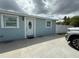 Charming single-story home with a white door, light blue exterior and a well-kept lawn at 2927 W Henry Ave, Tampa, FL 33614