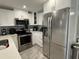 Modern kitchen featuring stainless steel appliances, white cabinetry, and a stylish backsplash at 2927 W Henry Ave, Tampa, FL 33614