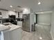 Bright kitchen features stainless steel appliances, white cabinetry, and contemporary tile flooring at 2927 W Henry Ave, Tampa, FL 33614