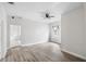 Open living room with a ceiling fan and light wood-look flooring. Door to additional space at 3105 N 16Th St, Tampa, FL 33605