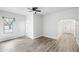 Open living room with ceiling fan and light wood-look flooring. Archway to additional space at 3105 N 16Th St, Tampa, FL 33605