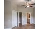 Bright bedroom featuring a ceiling fan, closet, wood-look tile flooring and an attached bathroom entrance at 3298 Covered Bridge W Dr, Dunedin, FL 34698