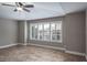 Well-lit bedroom with tray ceiling, ceiling fan, white plantation shutters and wood-look tile floor at 3298 Covered Bridge W Dr, Dunedin, FL 34698