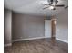 Bedroom with a ceiling fan, neutral-toned walls, wood-look tile flooring, and white baseboards at 3298 Covered Bridge W Dr, Dunedin, FL 34698
